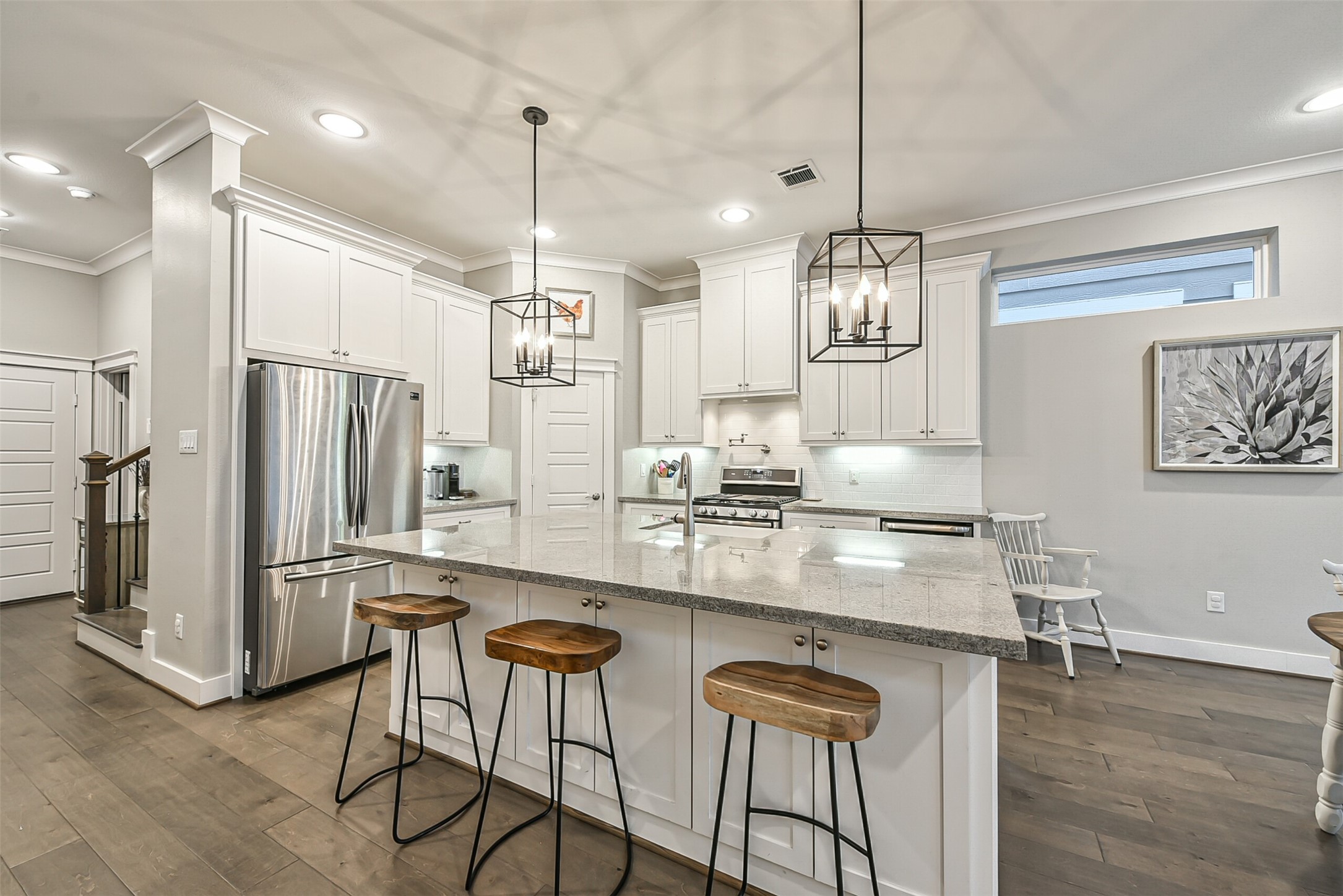 3222 Gillespie Street Houston, TX 77020 - Photo 26 of 43 a kitchen with stainless steel appliances kitchen island granite countertop a refrigerator a stove a kitchen island and chairs with wooden floor