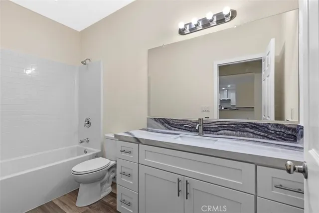 a bathroom with a granite countertop sink a toilet and a bathtub