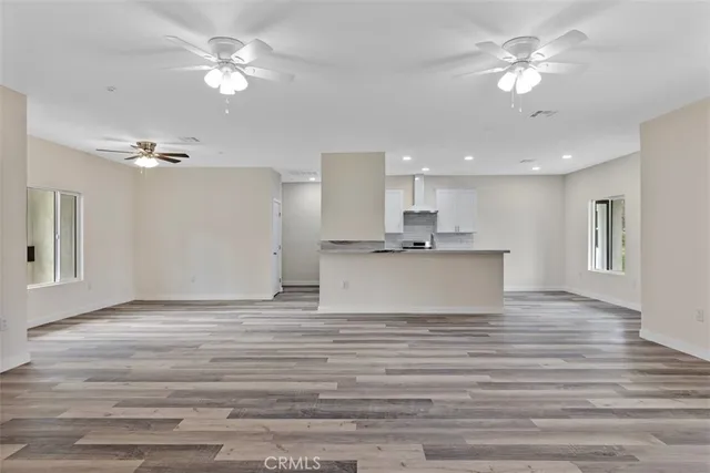 a view of kitchen with granite countertop cabinets and chandelier fan