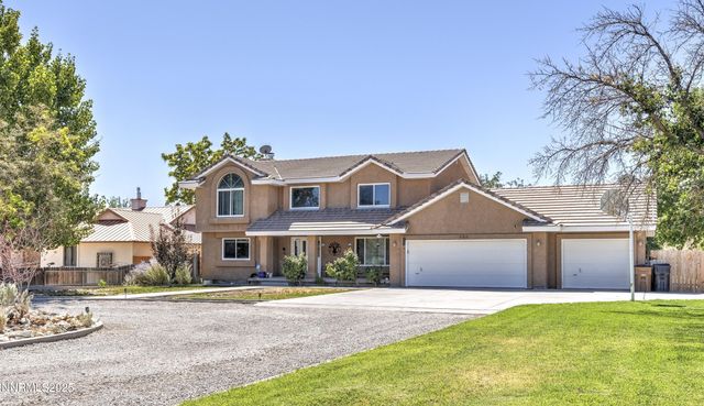 a front view of a house with a garden and tree