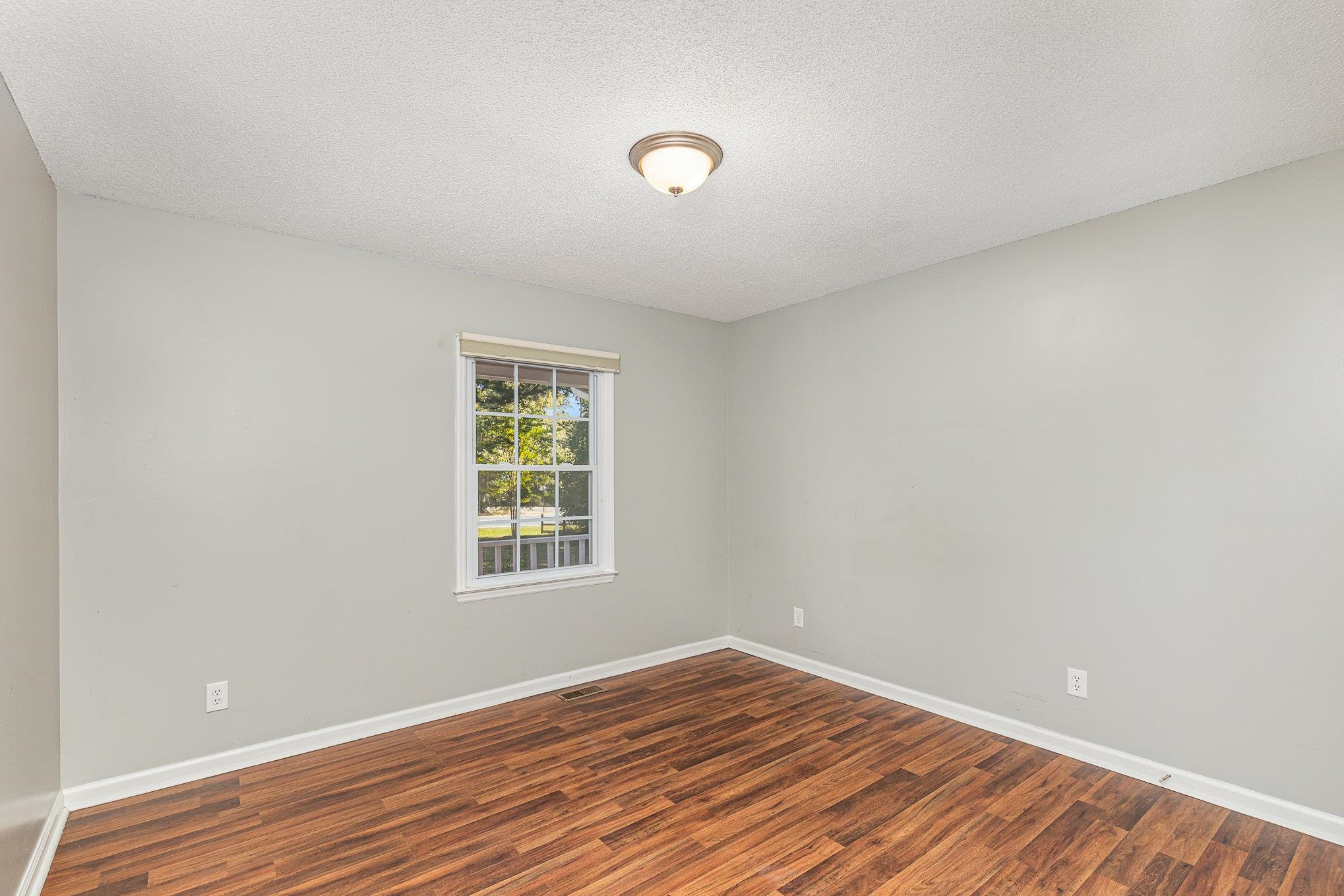 8724 Walter Myatt Road Willow Spring, NC 27592 - Photo 13 of 24 a view of an empty room with wooden floor and a window