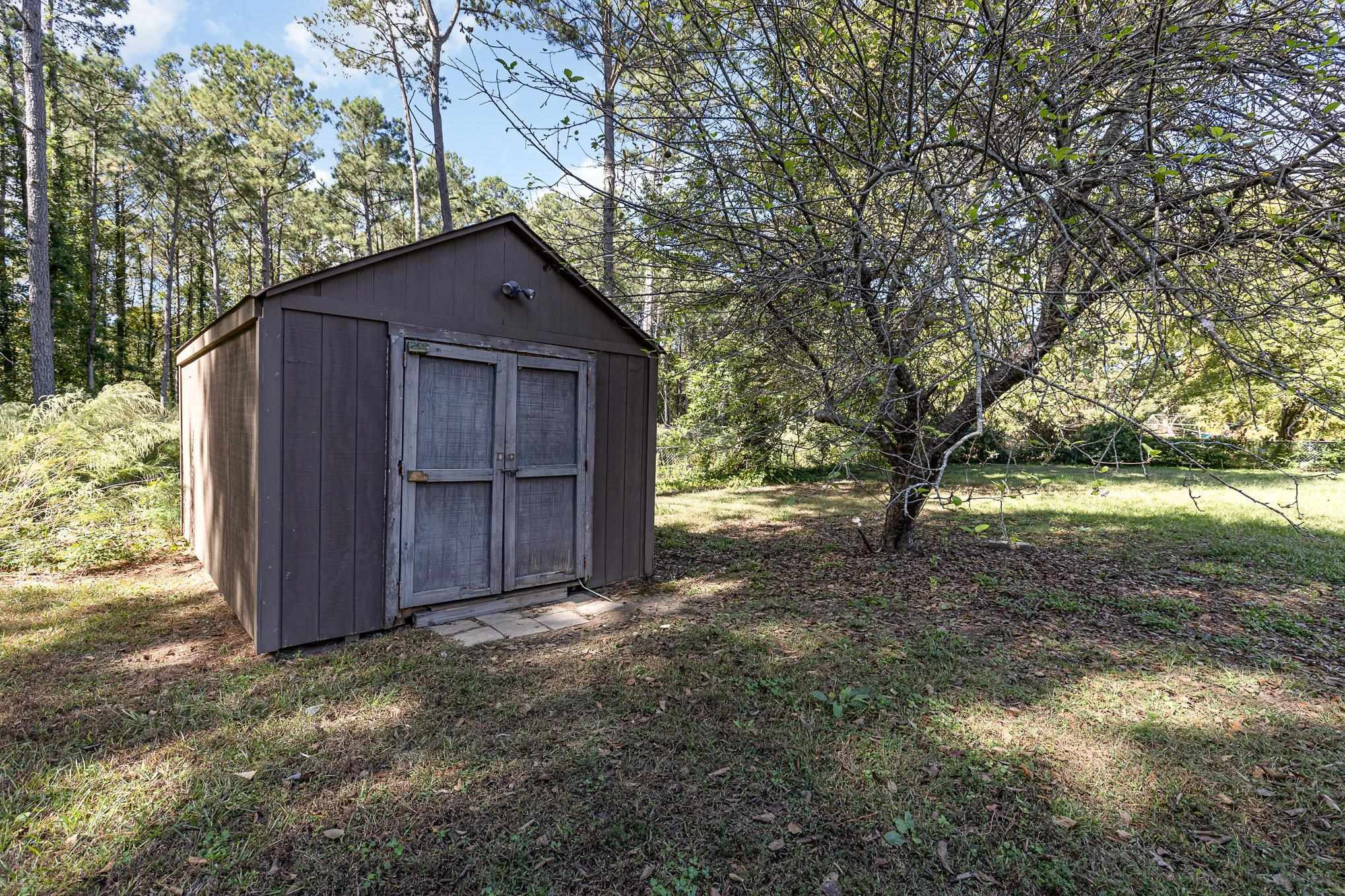 8724 Walter Myatt Road Willow Spring, NC 27592 - Photo 21 of 24 a view of backyard with large trees and wooden fence