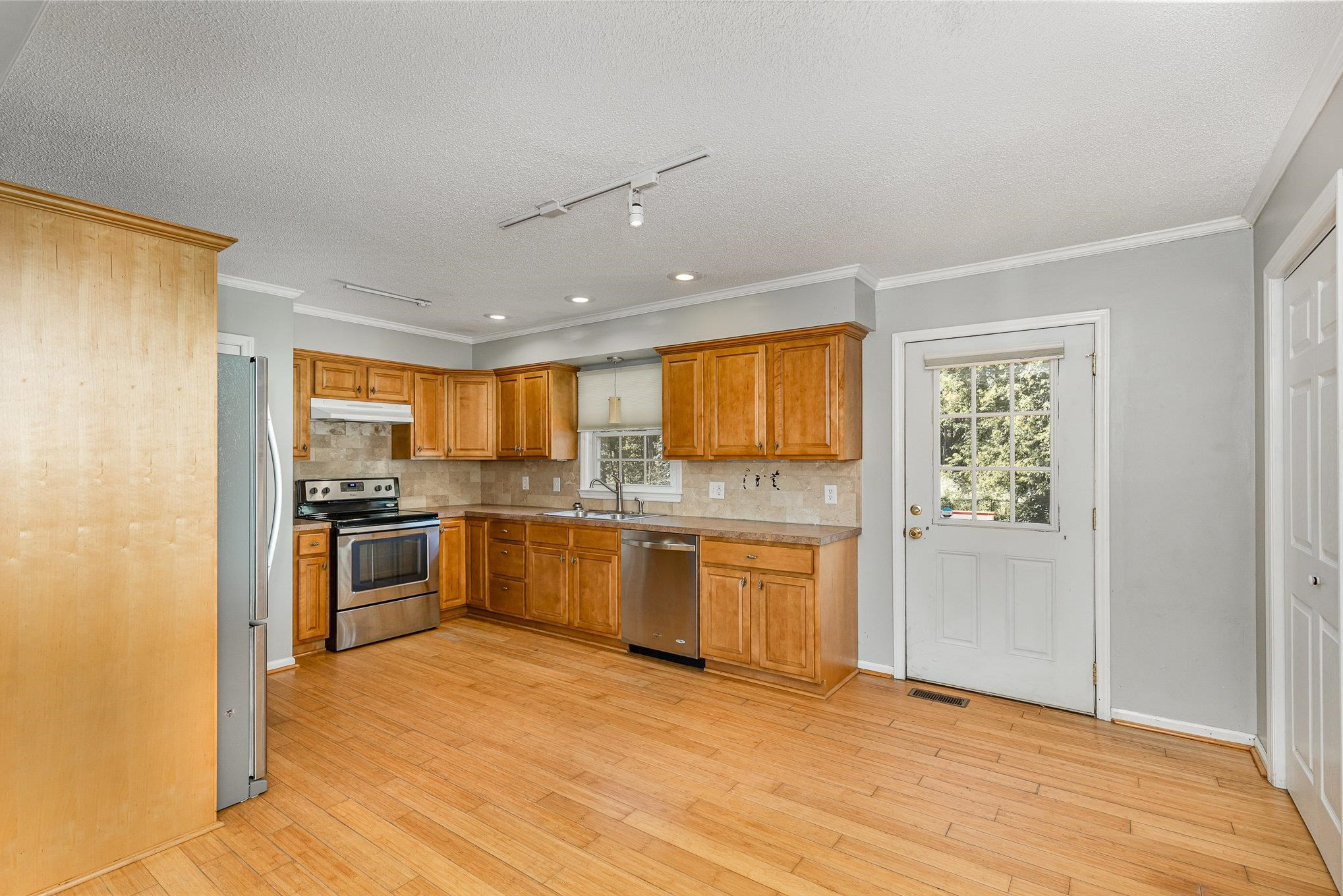 8724 Walter Myatt Road Willow Spring, NC 27592 - Photo 7 of 24 a kitchen with stainless steel appliances granite countertop a refrigerator a sink a stove and oven with wooden floor