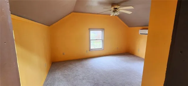 a view of a big room with a ceiling fan and a window