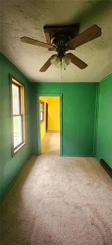 an empty room with a window and a ceiling fan