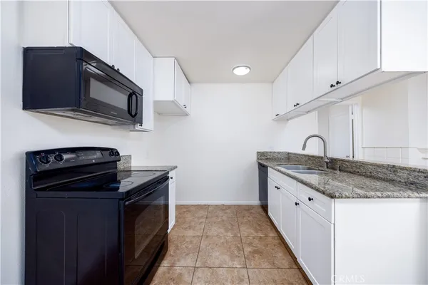 a kitchen with stainless steel appliances granite countertop a stove and a microwave
