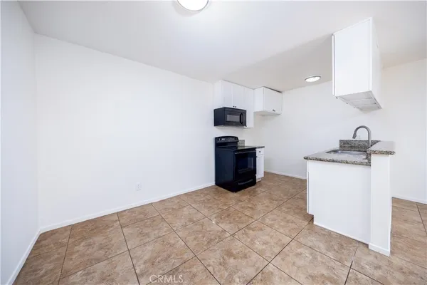a view of kitchen with microwave and cabinets
