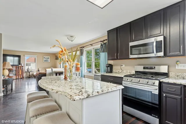a kitchen with granite countertop a stove and cabinets
