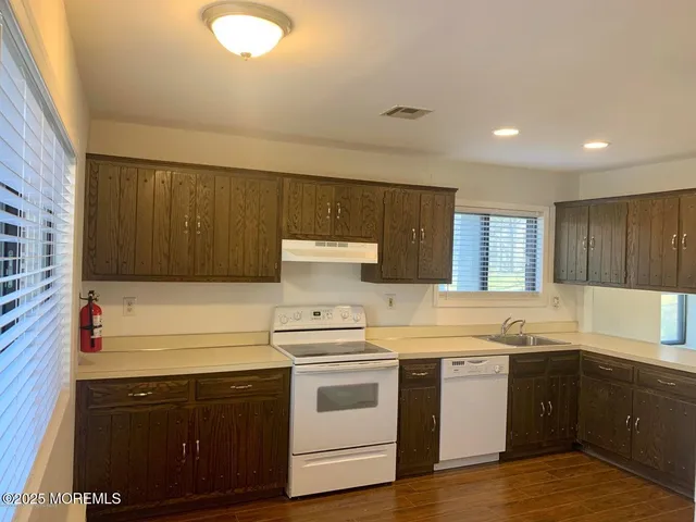 a kitchen with a stove sink and cabinets