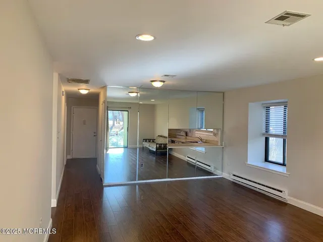 a view of a room with shelves and wooden floor
