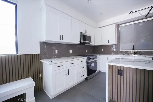 a kitchen with stainless steel appliances a sink stove and cabinets