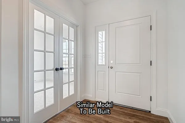 a view of a livingroom with wooden floor and windows with curtains