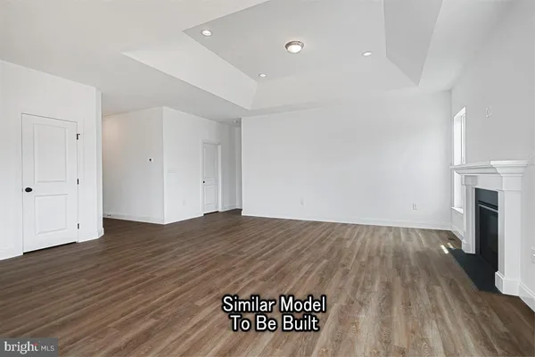 an empty room with wooden floor and fireplace