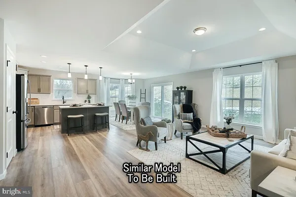 a living room with furniture kitchen view and a large window