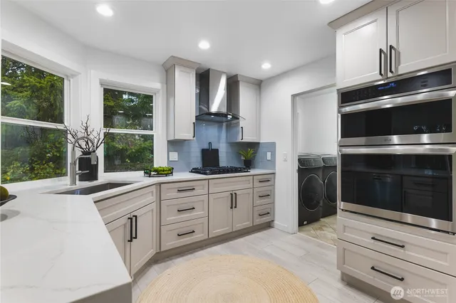 a kitchen with granite countertop white cabinets and stainless steel appliances