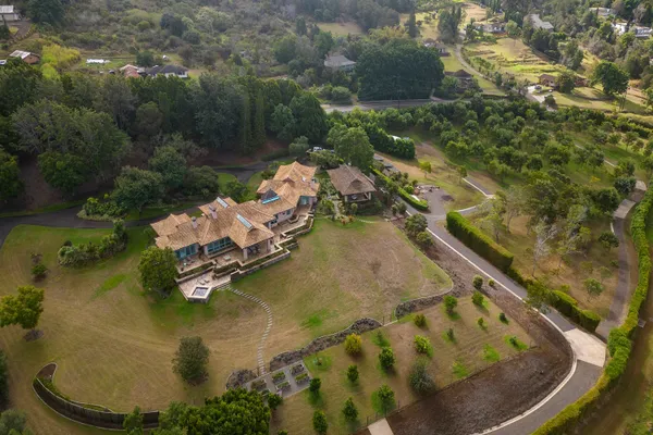 an aerial view of a house with swimming pool and outdoor seating