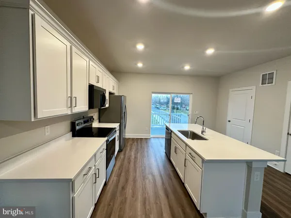 a view of an empty room with wooden floor and window