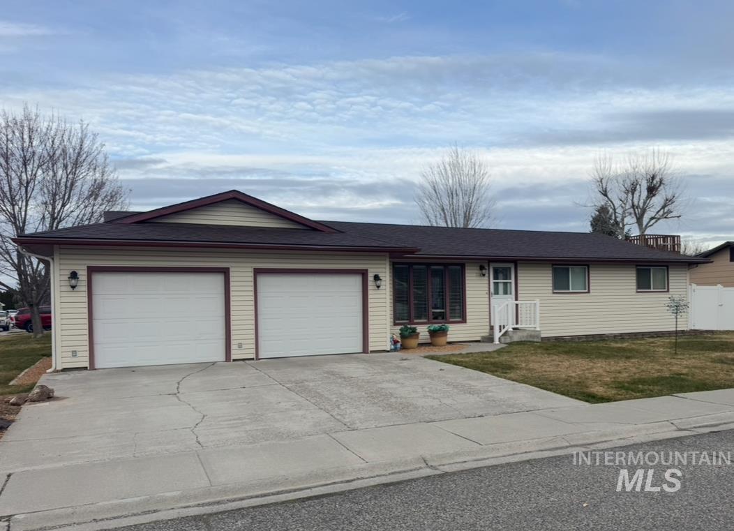 1145 Utah Street Gooding, ID 83330 - Photo 1 of 50 Ranch-style house with concrete driveway, an attached garage, and a front yard