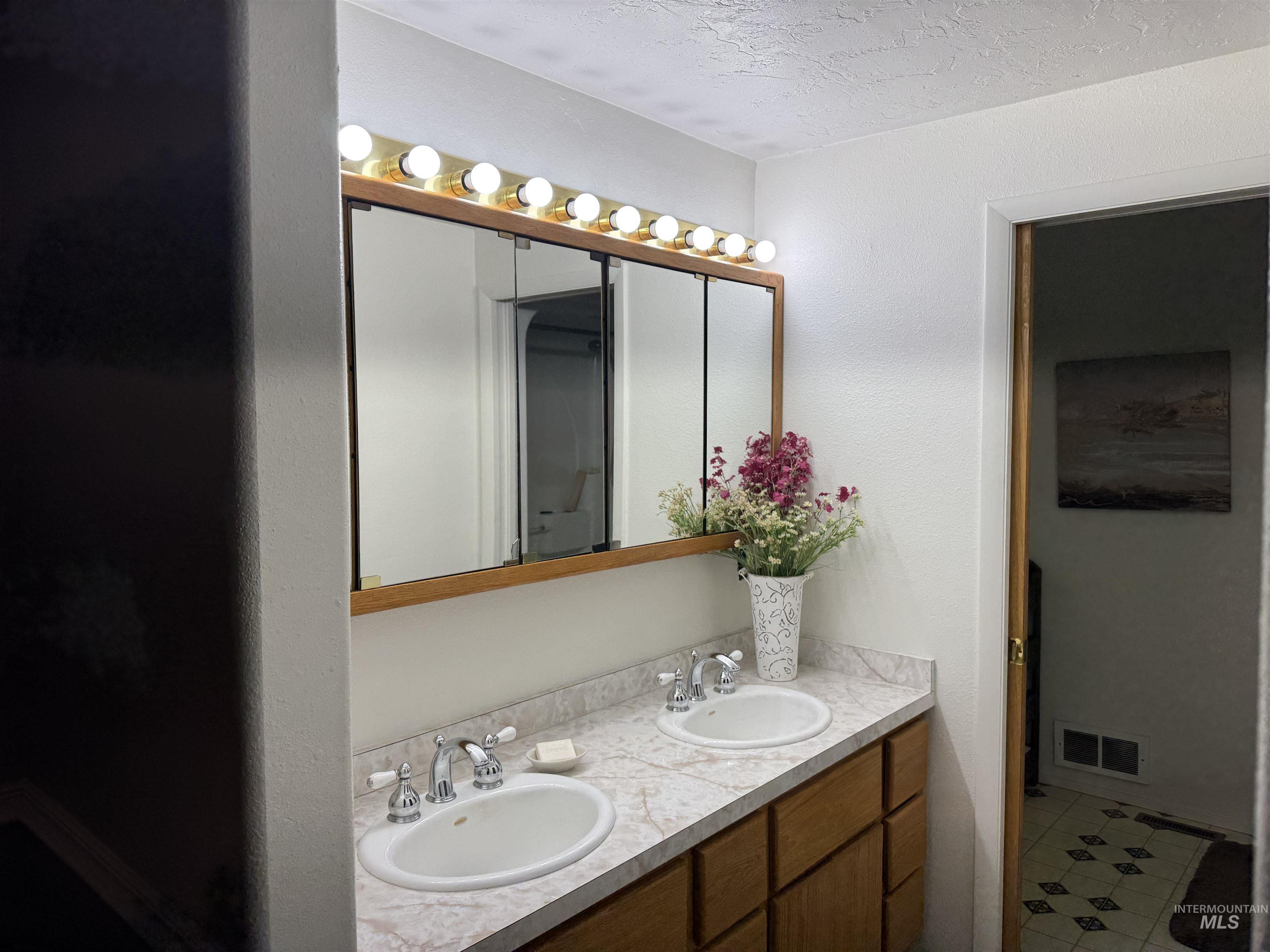 1145 Utah Street Gooding, ID 83330 - Photo 28 of 50 Full bath featuring double vanity, a textured ceiling, a textured wall, and light tile patterned flooring