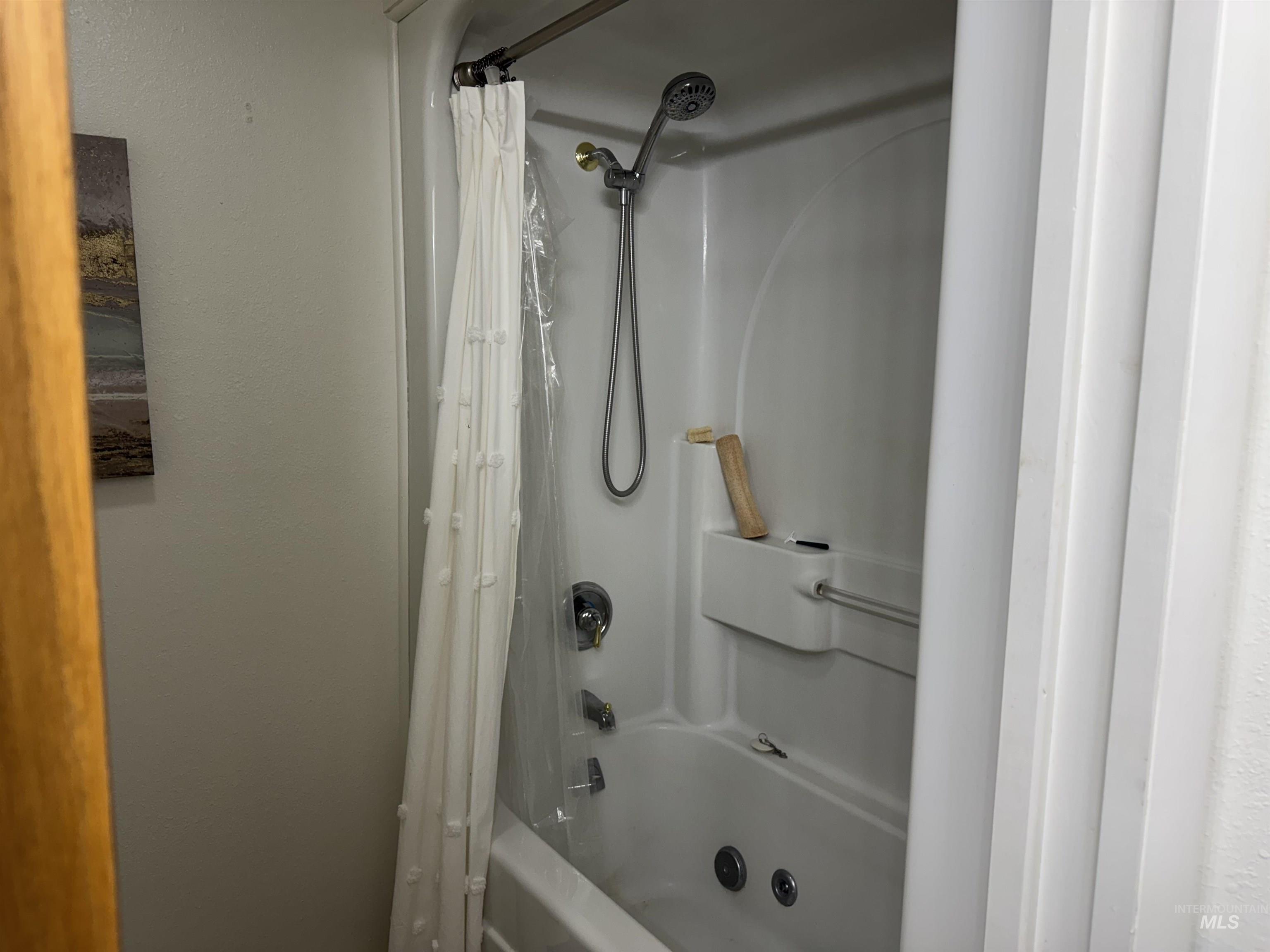 1145 Utah Street Gooding, ID 83330 - Photo 30 of 50 Bathroom with shower / bathtub combination with curtain and a textured wall