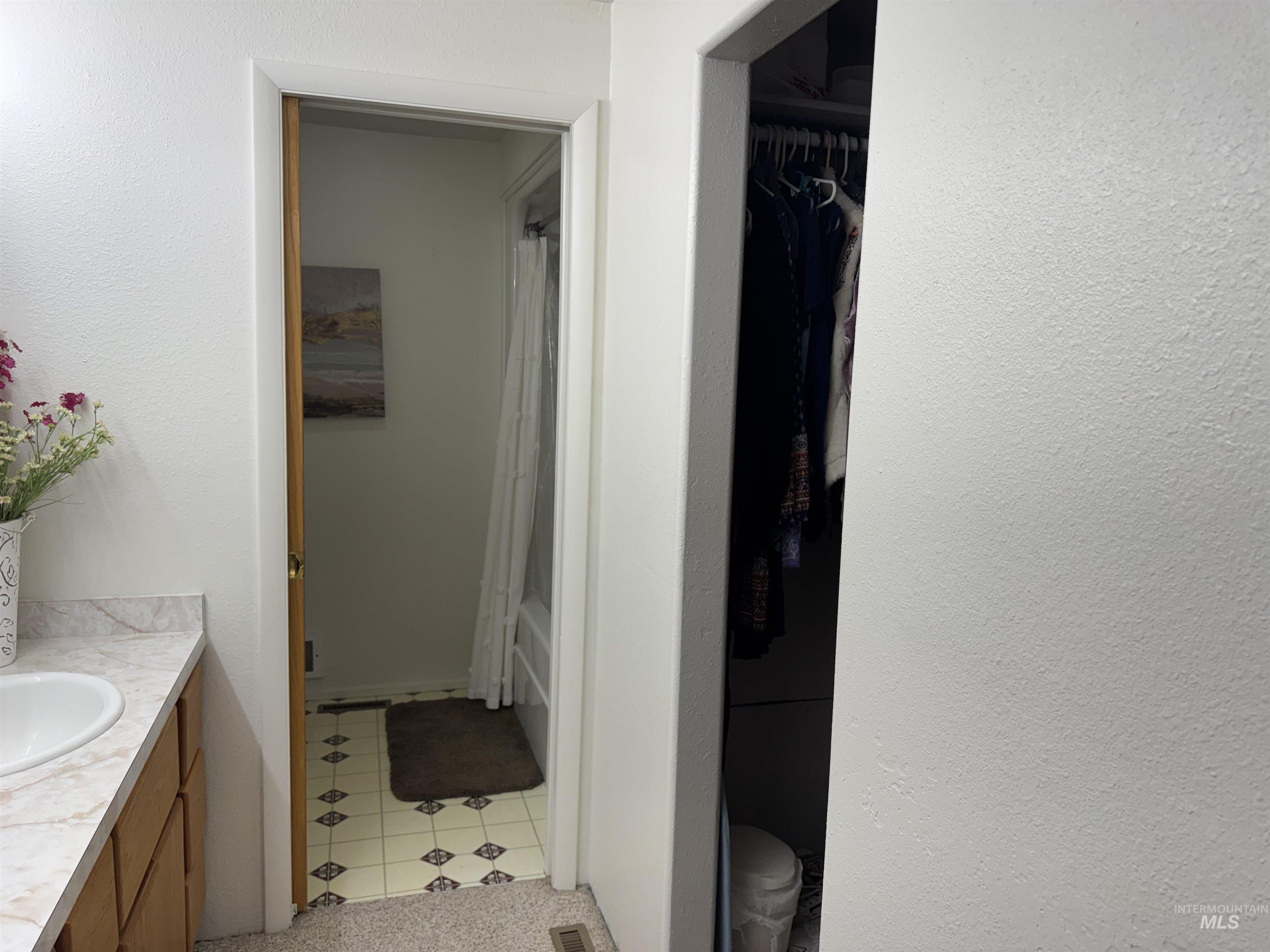 1145 Utah Street Gooding, ID 83330 - Photo 31 of 50 Bathroom with vanity, a textured wall, shower / tub combo with curtain, and a closet