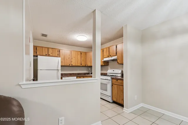 a kitchen with stainless steel appliances granite countertop a refrigerator and a stove top oven