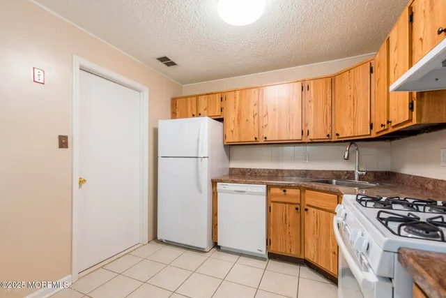 a kitchen with a stove a refrigerator and a sink