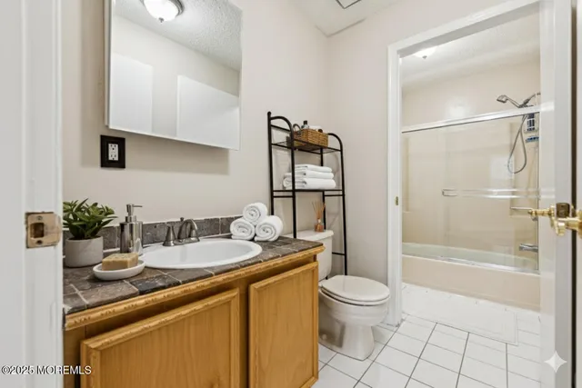 a bathroom with a granite countertop sink a toilet and shower