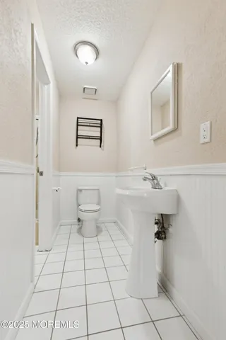 a bathroom with a sink a toilet and mirror