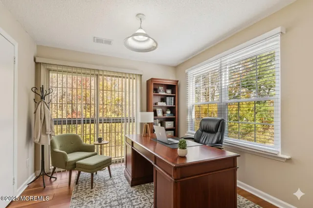 a view of a workspace with furniture and a window