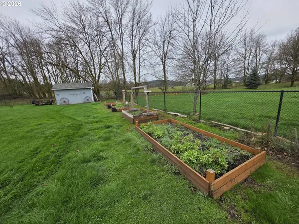 a view of a backyard with a garden and entertaining space