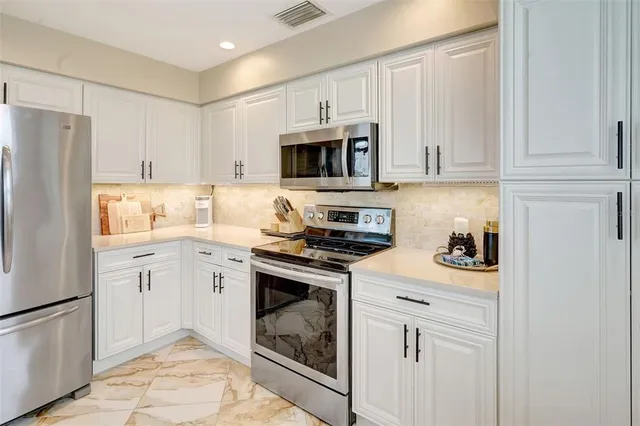 a kitchen with cabinets stainless steel appliances and sink