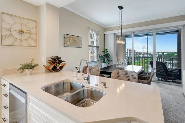 a kitchen with a refrigerator a sink and white cabinets next to a window