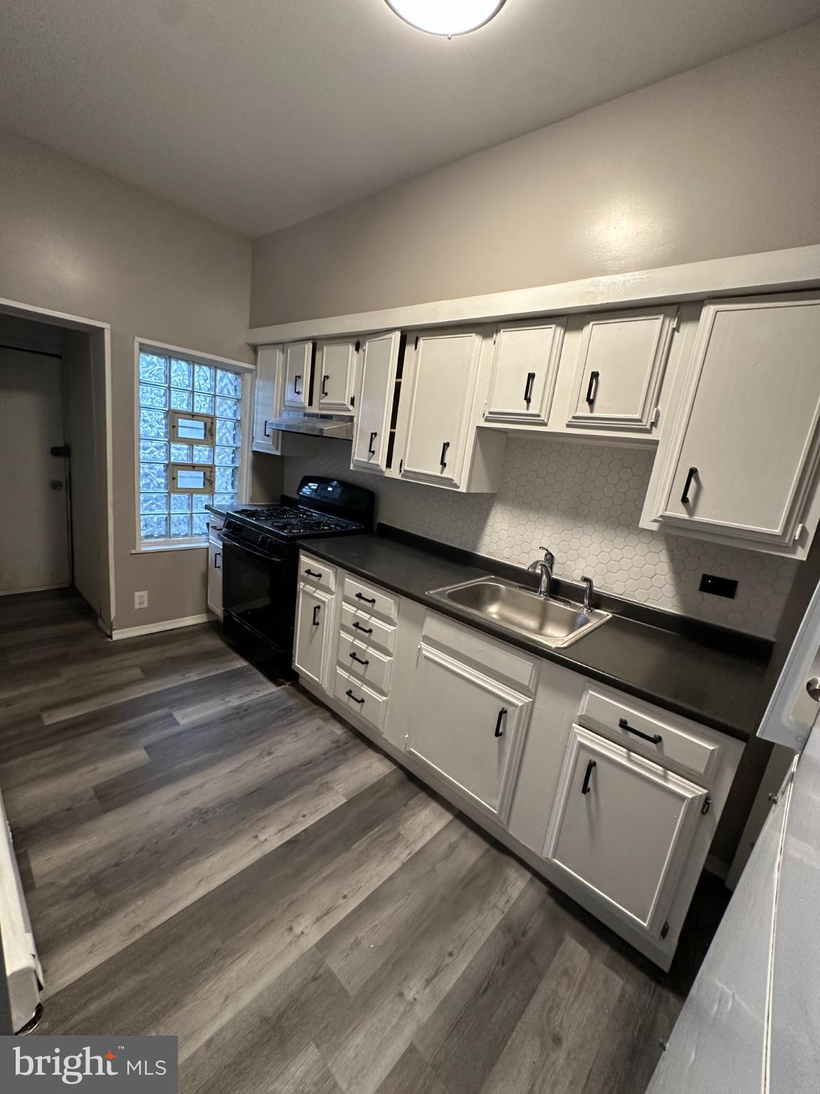 5913 Locust Street Philadelphia, PA 19139 - Photo 6 of 11 a kitchen with granite countertop a stove and a sink
