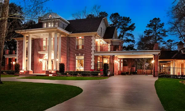a view of a livingroom with furniture wooden floor a chandelier and windows
