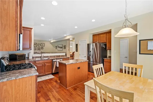 a kitchen with stainless steel appliances granite countertop a stove refrigerator and a sink