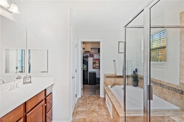 a bathroom with a tub sink and mirror
