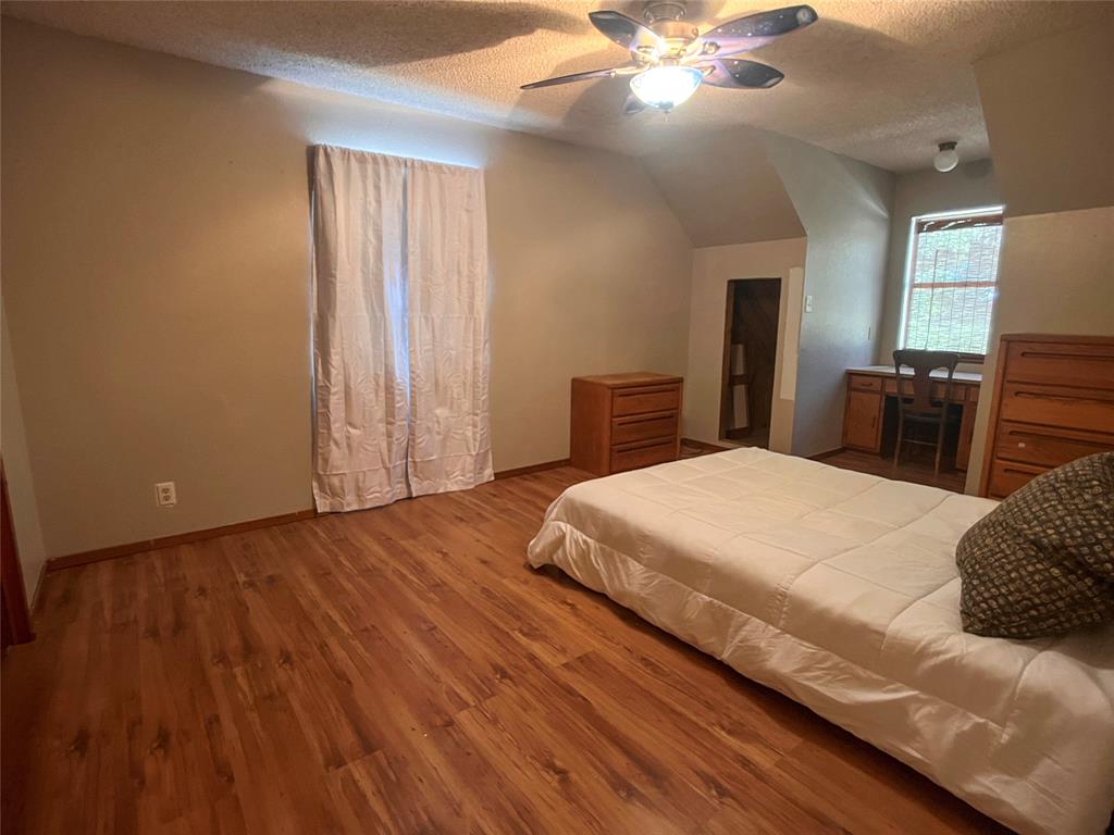 107 Private Road Whitney, TX 76692 - Photo 12 of 29 a bedroom with a large bed and a chandelier