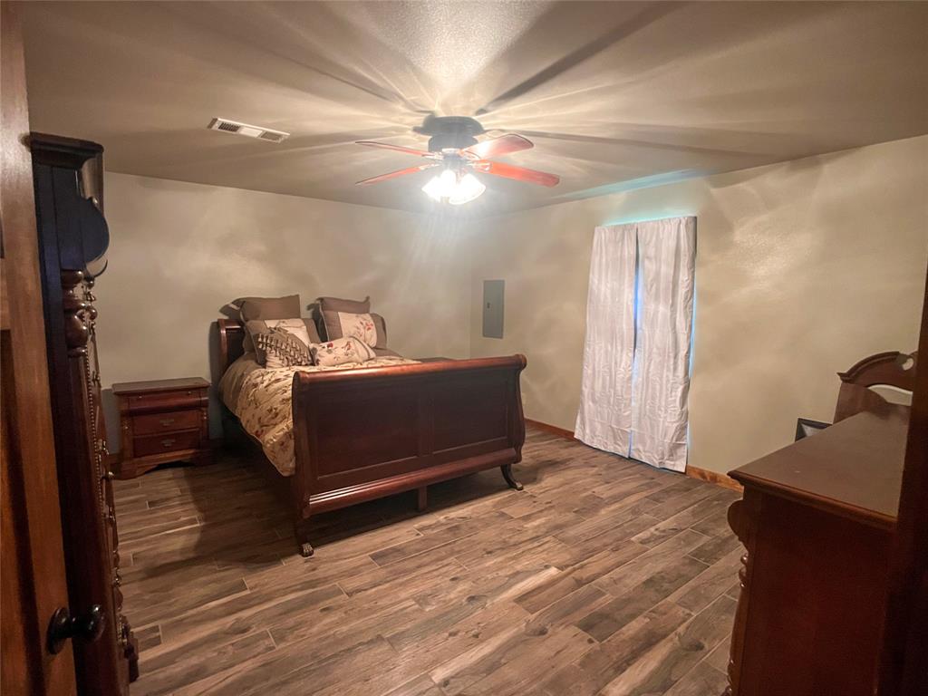 107 Private Road Whitney, TX 76692 - Photo 17 of 29 a bedroom with bed and a chandelier