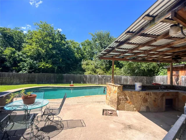 an aerial view of a house with a swimming pool and garden