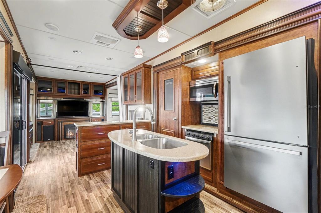 6800 Golf Course Boulevard, Unit H6 Punta Gorda, FL 33982 - Photo 9 of 15 a kitchen with stainless steel appliances granite countertop a refrigerator a oven a sink and a dining table with wooden floor