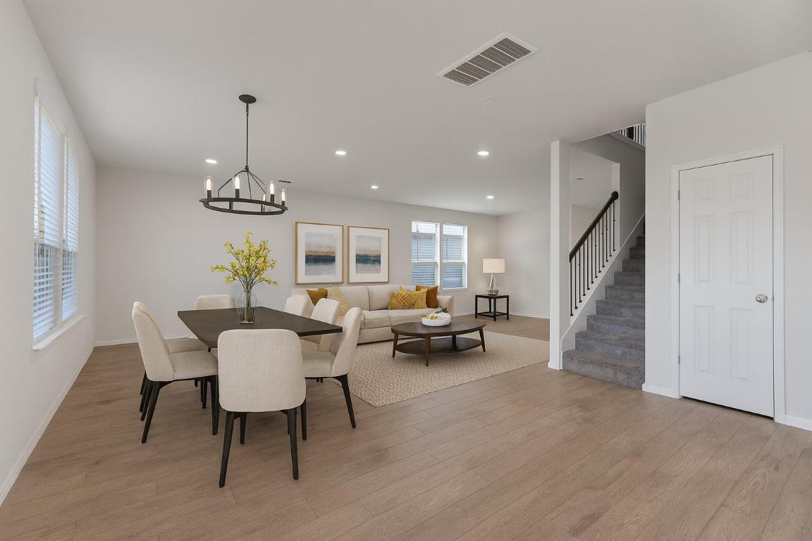 905 Duskywing Way Georgetown, TX 78626 - Photo 18 of 21 a view of a dining room and livingroom with furniture wooden floor a chandelier