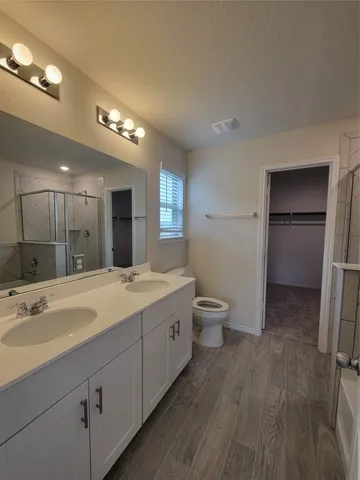 a spacious bathroom with a double vanity sink toilet and shower