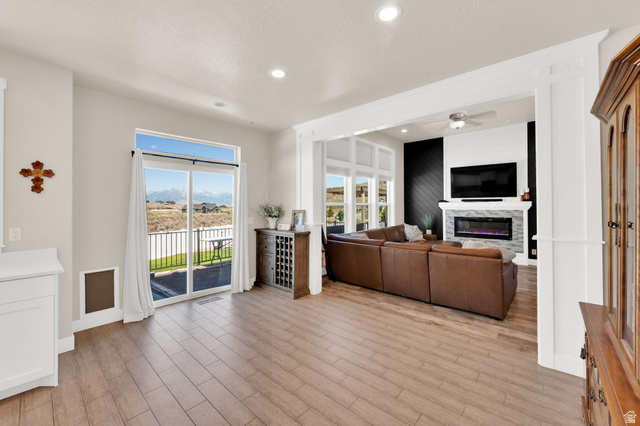 1857 Thunder Gulch Road Eagle Mountain, UT 84005 - Photo 11 of 50 Open-concept living area featuring wood-finish flooring, recessed lighting, and a sliding glass door to an outdoor deck