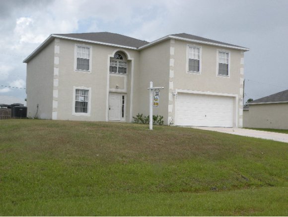 1354 Southeast Rabbit Palm Bay, FL 32909 - Photo 1 of 11 a front view of a house with a garden