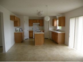 1354 Southeast Rabbit Palm Bay, FL 32909 - Photo 3 of 11 a kitchen with stainless steel appliances granite countertop a sink stove and refrigerator