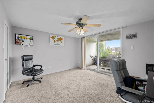 a view of a workspace with furniture and a window
