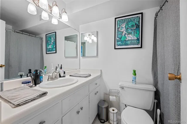 a bathroom with a toilet a sink a mirror and vanity