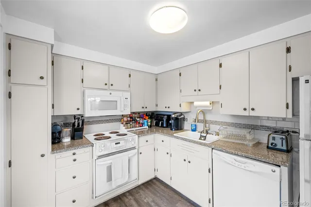 a kitchen with white cabinets and white appliances