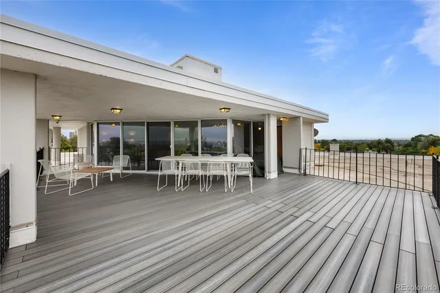 a view of a house with wooden deck and outdoor seating
